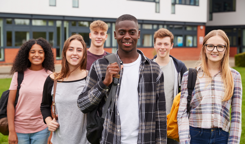 Six pupils smiling in front of college building