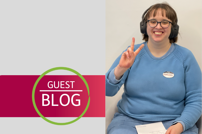 Photo of  Annabel from the Autistic Young Experts Panel, smiling and holding up peace sign. 