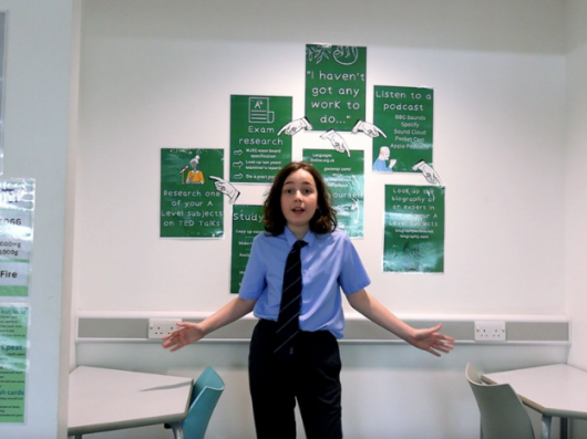 School student in front of wall with posters on 