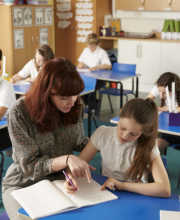 Teacher supporting pupil in classroom