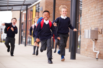 Children running in school uniform, smiling