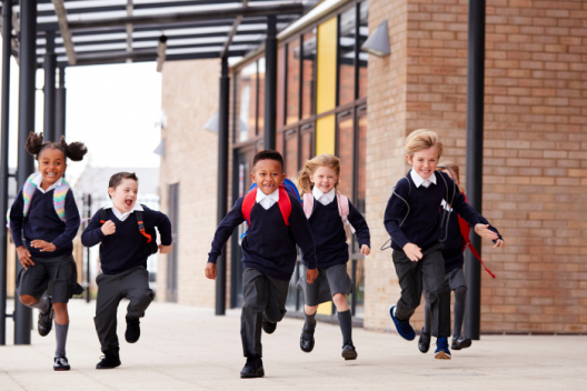 Children running in school uniform, smiling