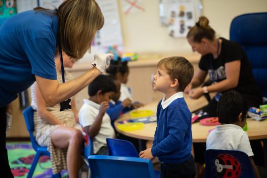 Young child in reception class with teacher