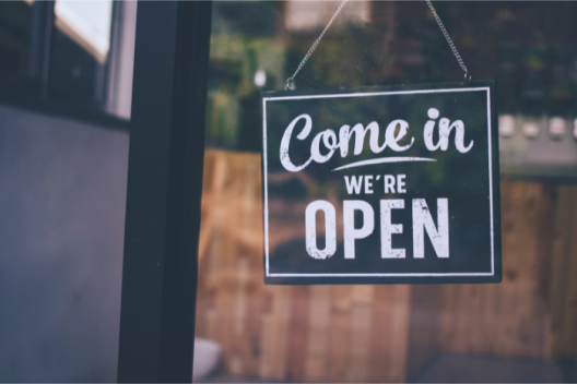 Shop window with a sign that reads: come in, we're open.