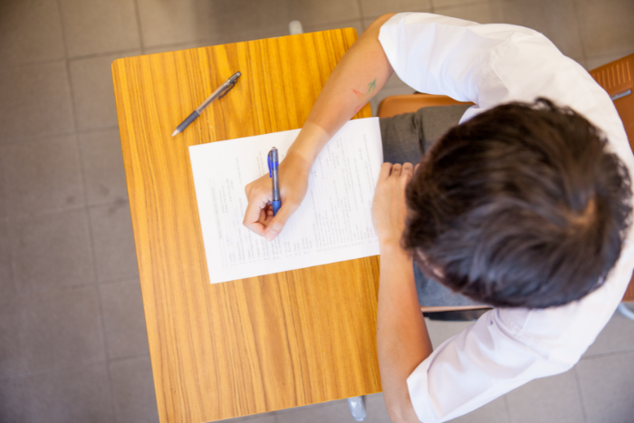 Photo of pupil at desk in exam, taken from above their head.