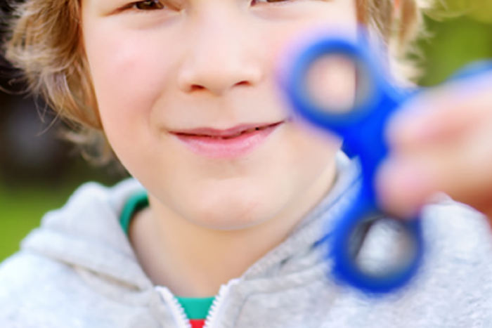 Child holding fidget spinner up to camera
